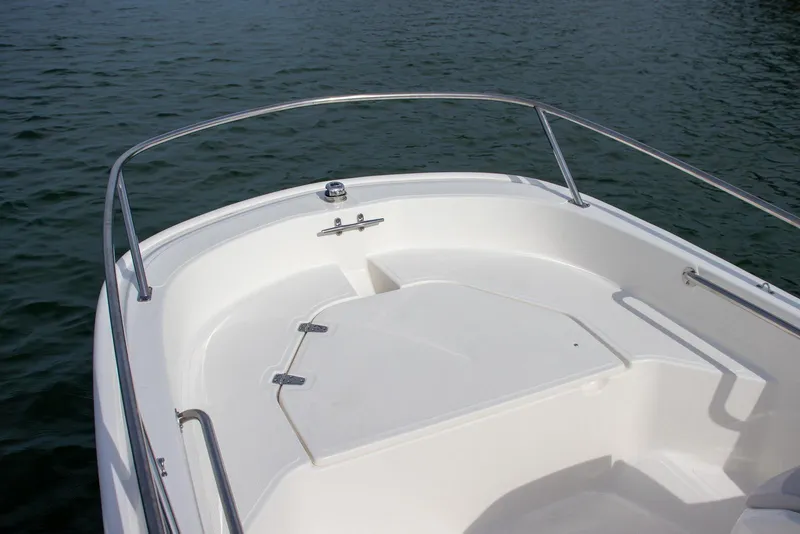 Slide: The Image of 2026 Boston Whaler 130 Super Sport boat bow on calm water. - 3