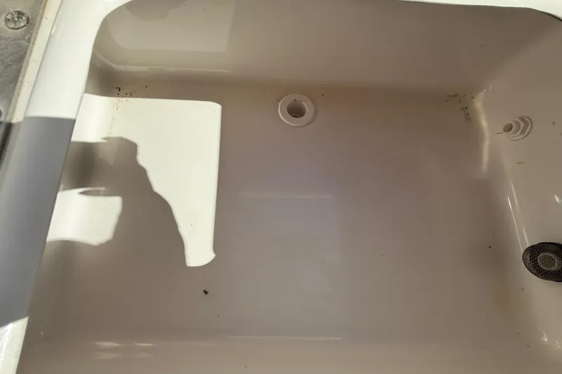 Slide: The Image of Clean compartment of 2022 NauticStar 231 Hybrid boat, featuring drainage and plug. - 10