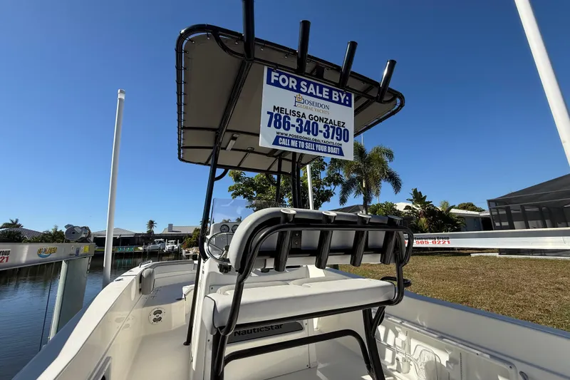 Slide: The Image of 2022 NauticStar 231 Hybrid boat for sale, docked near waterfront homes. - 13