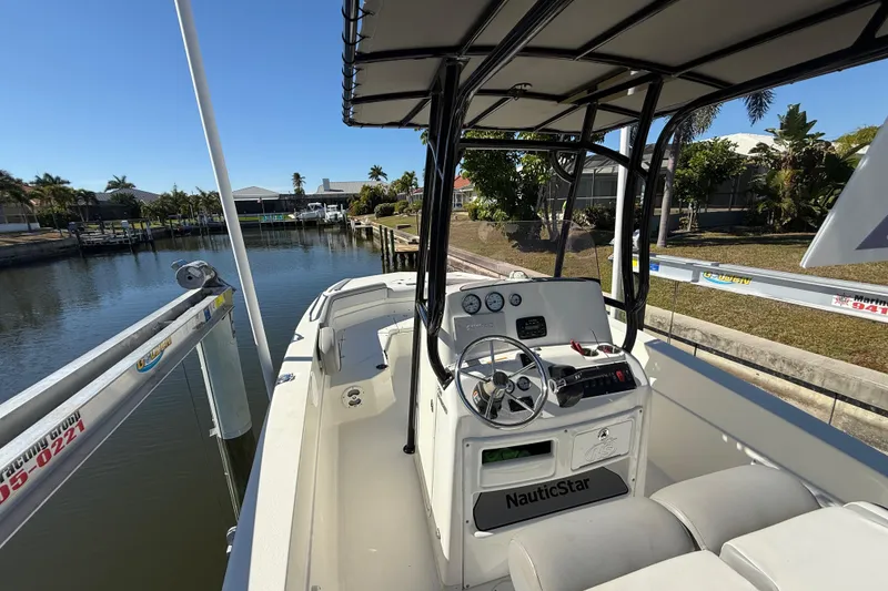 Slide: The Image of 2022 NauticStar 231 Hybrid boat docked by a scenic canal. - 15