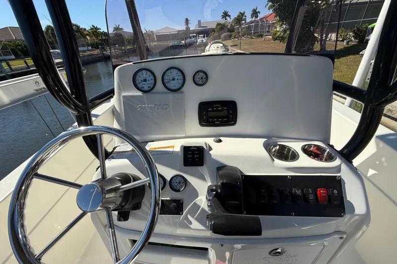 Slide: The Image of 2022 NauticStar 231 Hybrid boat dashboard with steering wheel and control panel. - 16