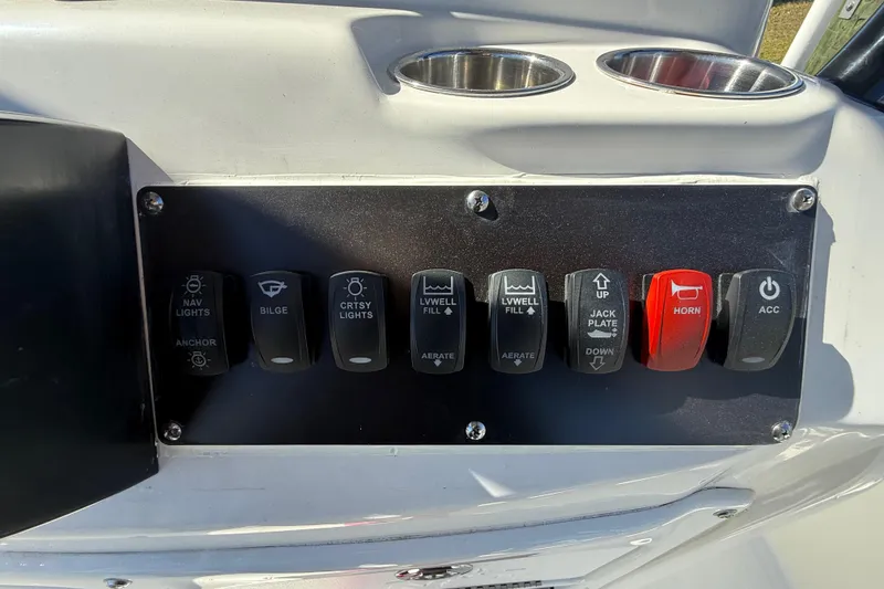 Slide: The Image of Control panel of 2022 NauticStar 231 Hybrid boat with various switches. - 17