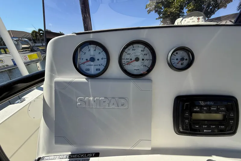 Slide: The Image of 2022 NauticStar 231 Hybrid dashboard with Simrad display and Yamaha gauges. - 21