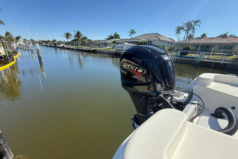 Slide: The Image of 2022 NauticStar 231 Hybrid boat with Yamaha engine on a sunny waterfront. - 3