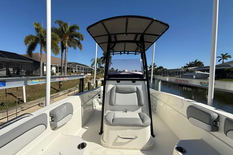Slide: The Image of 2022 NauticStar 231 Hybrid boat interior with seating, canopy, and canal view. - 30
