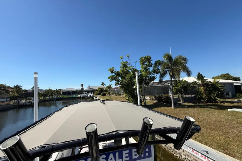 Slide: The Image of 2022 NauticStar 231 Hybrid boat docked near waterfront homes under clear blue sky. - 39