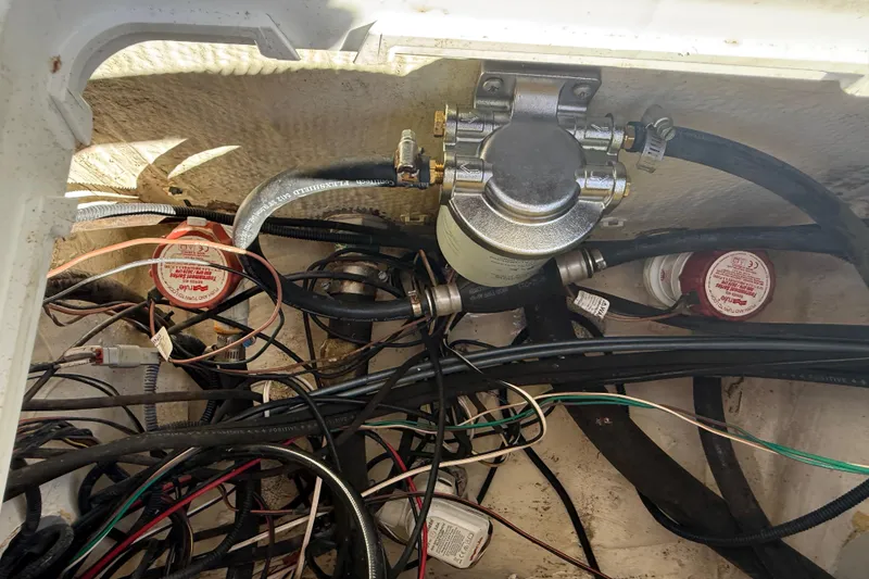 Slide: The Image of 2022 NauticStar 231 Hybrid boat wiring and fuel system components in compartment. - 5