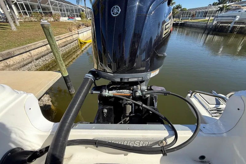 Slide: The Image of 2022 NauticStar 231 Hybrid boat engine at dockside, showcasing powerful outboard motor. - 6