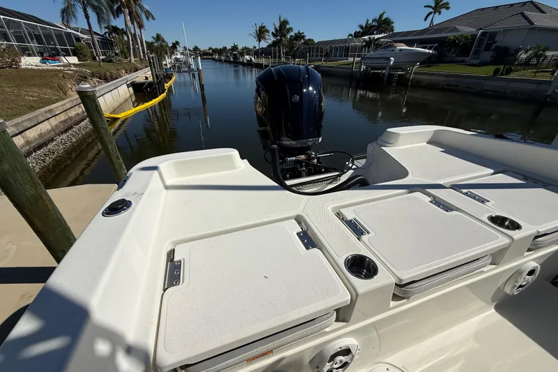 Slide: The Image of 2022 NauticStar 231 Hybrid boat docked in a sunny canal setting. - 7