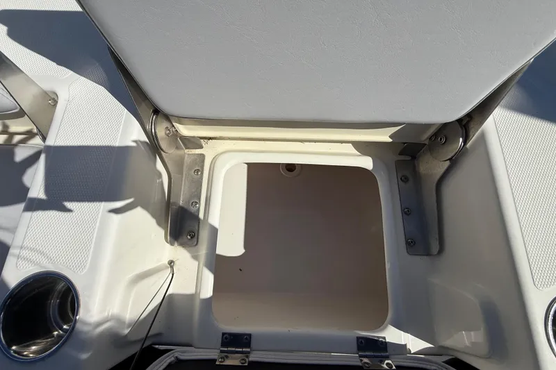 Slide: The Image of Open storage compartment on 2022 NauticStar 231 Hybrid boat, featuring stainless steel hinges. - 9