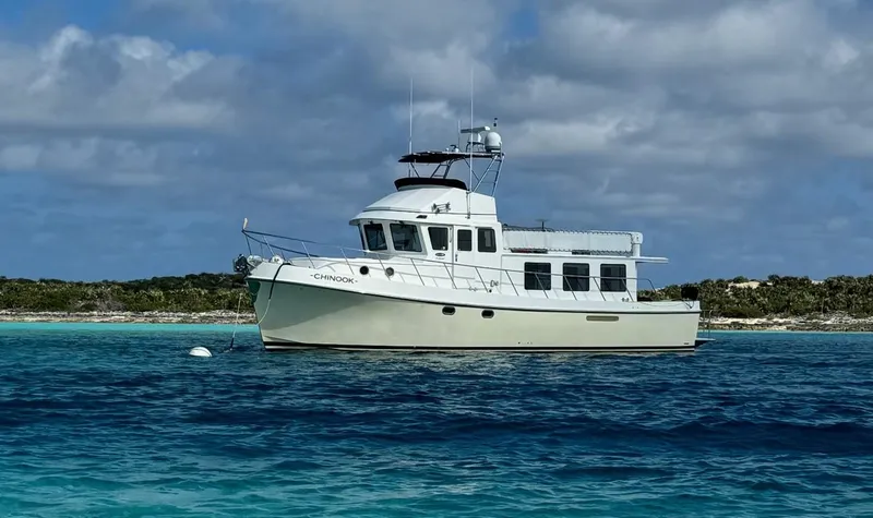 Slide: The Image of 2010 American Tug 49 Limited boat anchored in clear blue waters under a cloudy sky. - 102