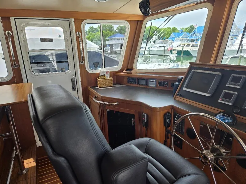 Slide: The Image of Interior of 2010 American Tug 49 Limited, featuring helm station and leather seating. - 31