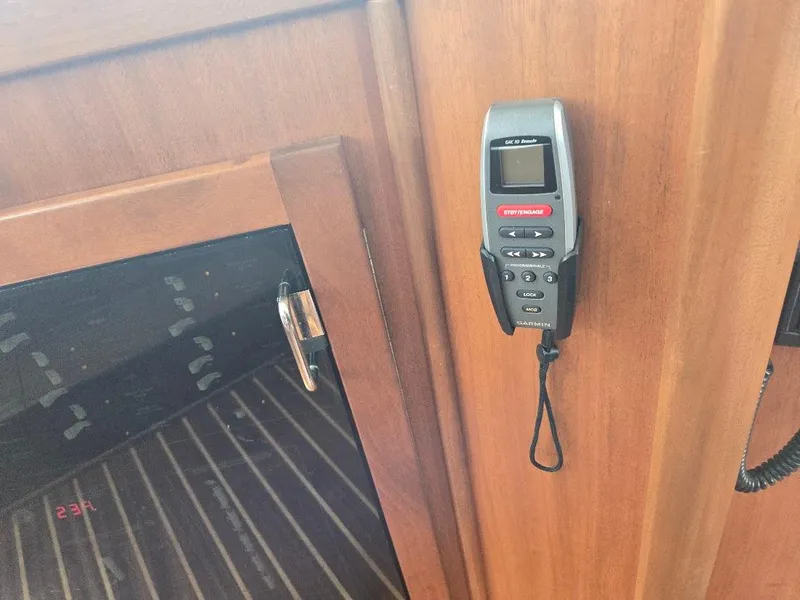 Slide: The Image of Remote control mounted on wooden panel inside 2010 American Tug 49 Limited boat. - 47
