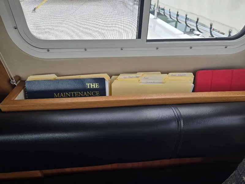 Slide: The Image of Maintenance book and folders on American Tug 49 Limited, 2010 model, near window. - 50