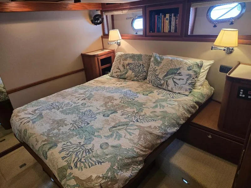 Slide: The Image of Cozy bedroom in 2010 American Tug 49 Limited with floral bedding and warm lighting. - 6