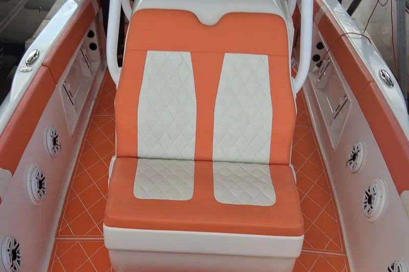 Slide: The Image of 2006 Renegade 32 Cuddy boat interior with orange and white seating and flooring. - 14