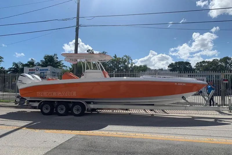 Slide: The Image of 2006 Renegade 32 Cuddy boat on trailer, vibrant orange and white design. - 2