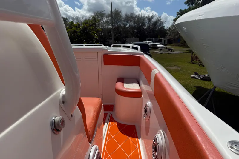 Slide: The Image of 2006 Renegade 32 Cuddy boat interior with orange and white seating, outdoor setting. - 33