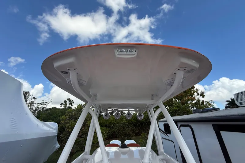Slide: The Image of 2006 Renegade 32 Cuddy boat with T-top under a clear blue sky. - 38