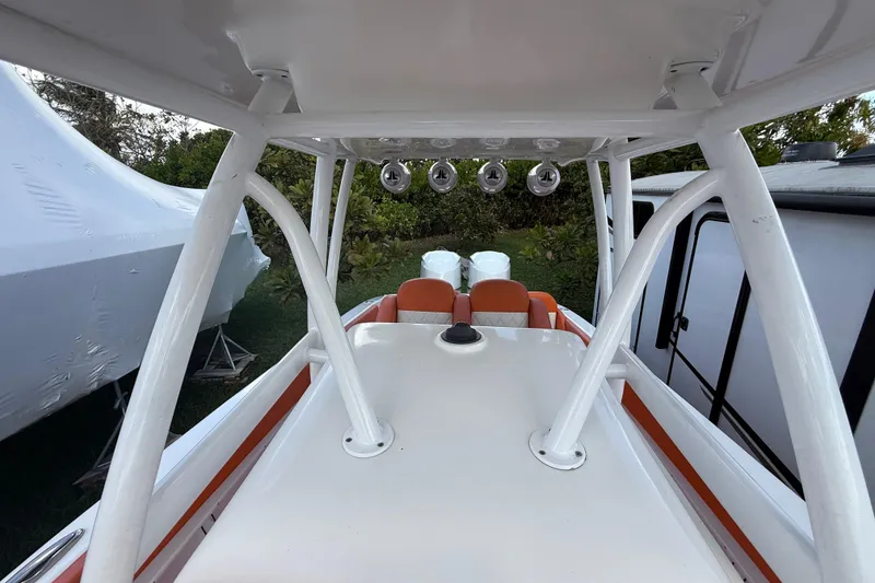 Slide: The Image of 2006 Renegade 32 Cuddy boat interior with white and orange seating, outdoor setting. - 39