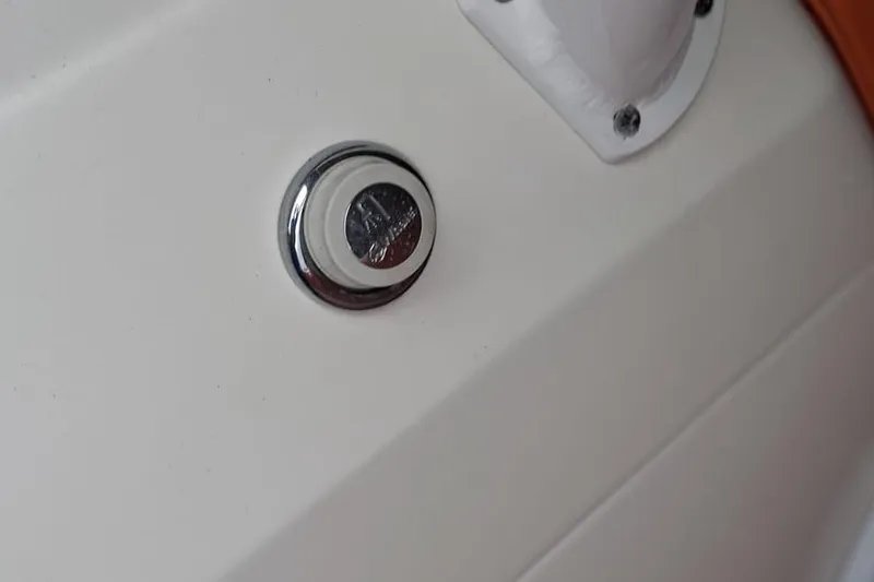 Slide: The Image of Close-up of a 2006 Renegade 32 Cuddy boat detail, featuring a chrome button. - 41
