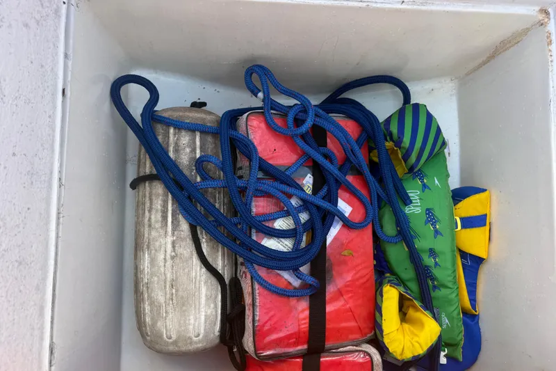 Slide: The Image of Storage compartment of 2006 Renegade 32 Cuddy with ropes, fender, and life jackets. - 44