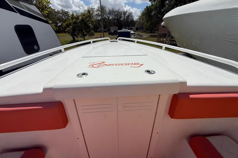 Slide: The Image of 2006 Renegade 32 Cuddy boat with red accents, docked outdoors under a cloudy sky. - 51