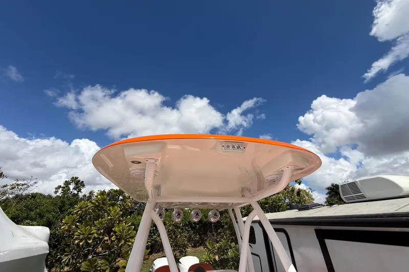 Slide: The Image of 2006 Renegade 32 Cuddy boat top against a bright blue sky with clouds. - 55