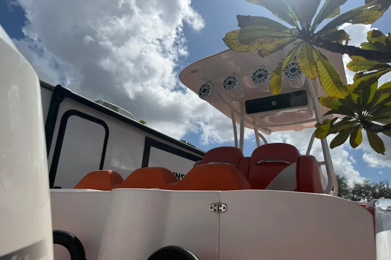 Slide: The Image of 2006 Renegade 32 Cuddy boat with orange seats and canopy speakers under a cloudy sky. - 58