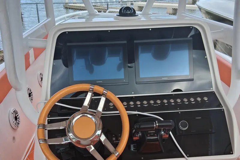 Slide: The Image of 2006 Renegade 32 Cuddy boat dashboard with dual Garmin screens and a stylish steering wheel. - 6