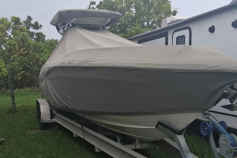 Slide: The Image of Covered 2006 Renegade 32 Cuddy boat on trailer, parked beside RV. - 61