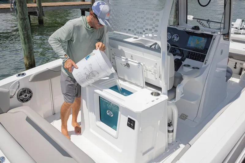 Slide: The Image of Man pouring water into livewell on 2025 Hurricane Center Console 24 OB boat. - 11