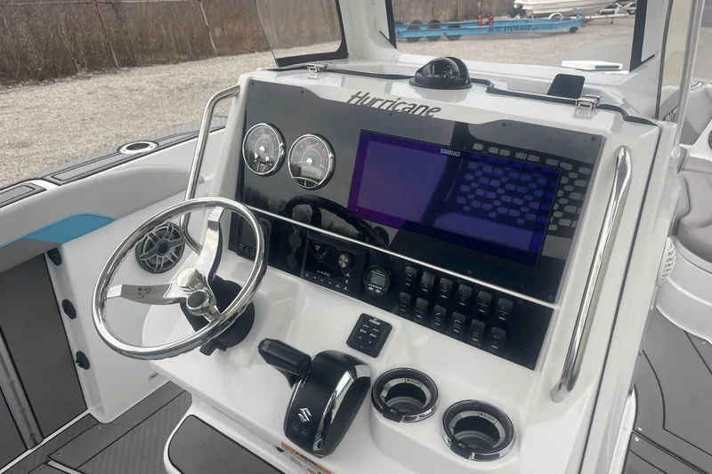 Slide: The Image of 2025 Hurricane Center Console 24 OB boat dashboard with steering wheel and navigation controls. - 19