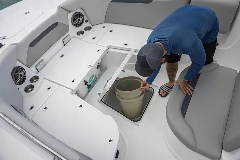 Slide: The Image of Man inspecting storage compartment on 2025 Hurricane Center Console 24 OB boat. - 50