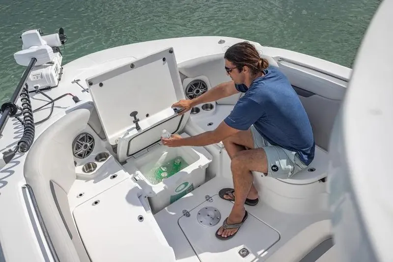 Slide: The Image of Man accessing cooler on 2025 Hurricane Center Console 24 OB boat. - 56