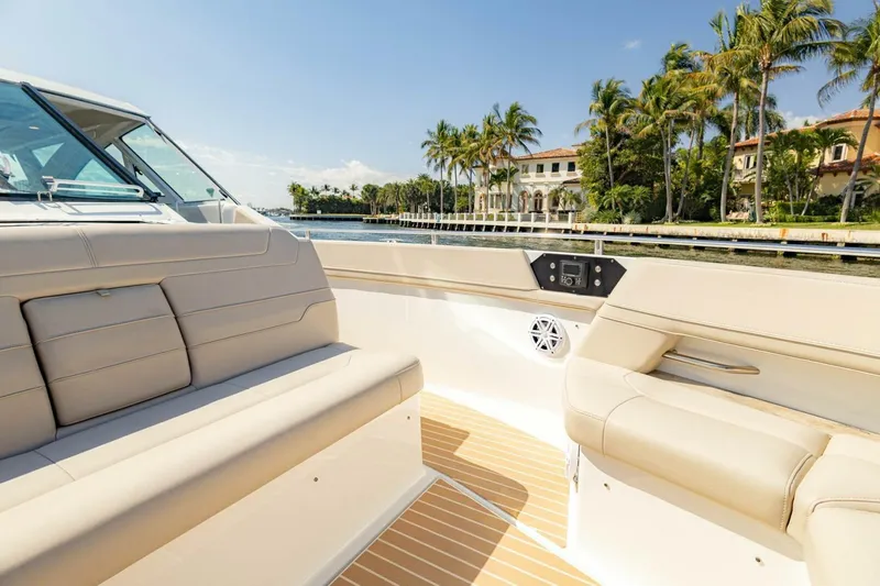 Slide: The Image of 2018 Formula 430 Super Sport Crossover boat interior with luxurious seating, palm trees, and waterfront view. - 34