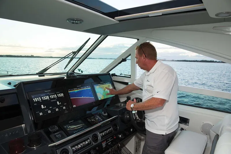 Slide: The Image of Manufacturer Provided Image: Man navigating 2018 Formula 430 Super Sport Crossover yacht using advanced touchscreen controls. - 9