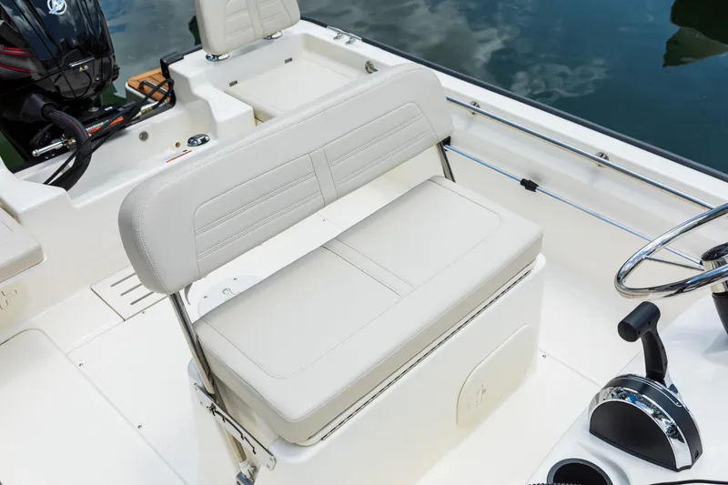 Slide: The Image of 2026 Boston Whaler 170 Montauk boat interior with cushioned seating and steering console. - 2