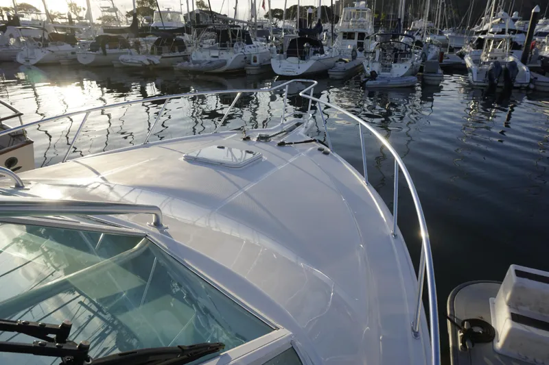 Slide: The Image of 2005 Cabo 35 Express yacht docked in a marina, surrounded by other boats. - 11