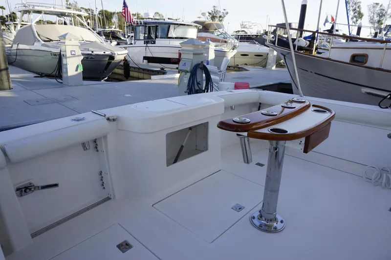 Slide: The Image of 2005 Cabo 35 Express boat docked, featuring a clean deck and fishing rod holders. - 14