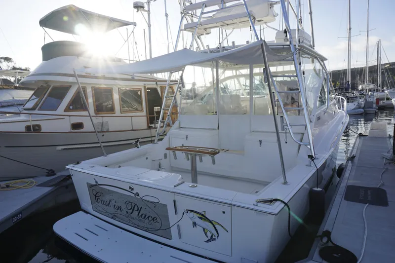 Slide: The Image of 2005 Cabo 35 Express boat docked at marina with sunlit background. - 16