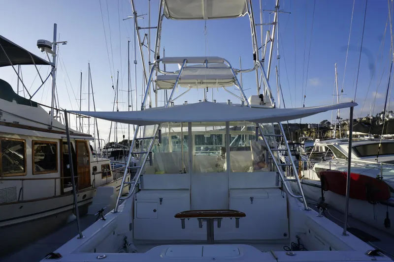 Slide: The Image of 2005 Cabo 35 Express boat docked at marina, surrounded by other vessels. - 19