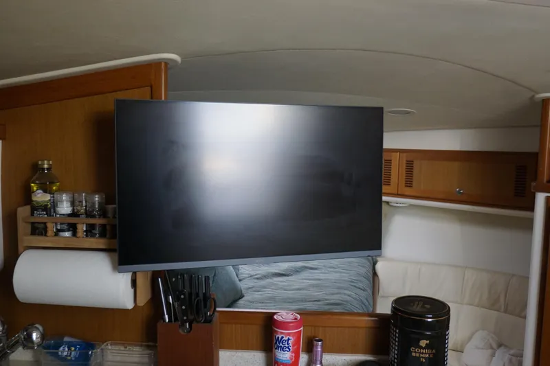 Slide: The Image of Interior of 2005 Cabo 35 Express boat with TV, kitchen items, and seating area. - 23