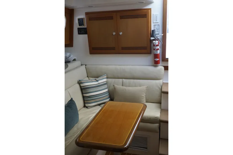 Slide: The Image of Interior of 2005 Cabo 35 Express yacht with cozy seating and wooden table. - 24