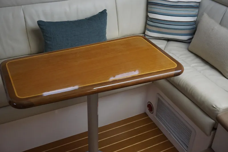 Slide: The Image of Interior of 2005 Cabo 35 Express yacht with wooden table and cushioned seating. - 25