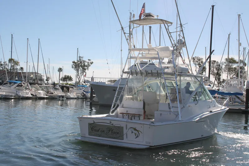 Slide: The Image of 2005 Cabo 35 Express yacht docked in a marina with sailboats. - 5