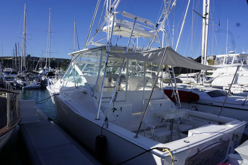 Slide: The Image of 2005 Cabo 35 Express yacht docked in a marina, surrounded by sailboats. - 6