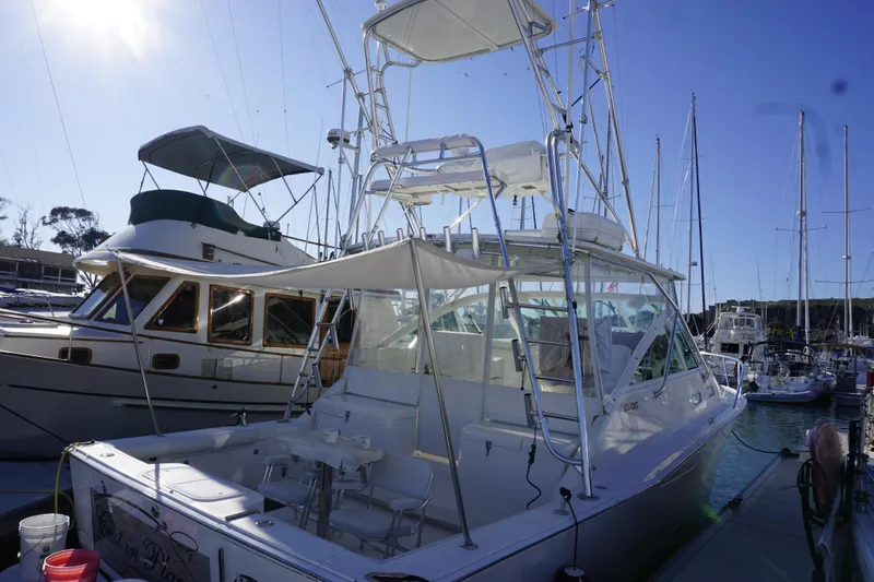 Slide: The Image of 2005 Cabo 35 Express boat docked at marina under clear blue sky. - 7