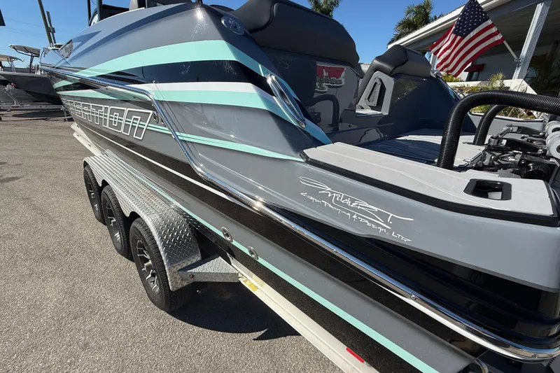 Slide: The Image of 2026 Sunsation 32 CCX boat with custom design, parked on a trailer, American flag in background. - 13
