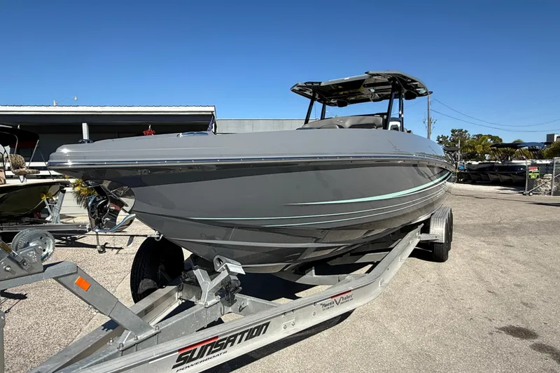 Slide: The Image of 2026 Sunsation 32 CCX boat on trailer, sleek gray design under clear blue sky. - 3